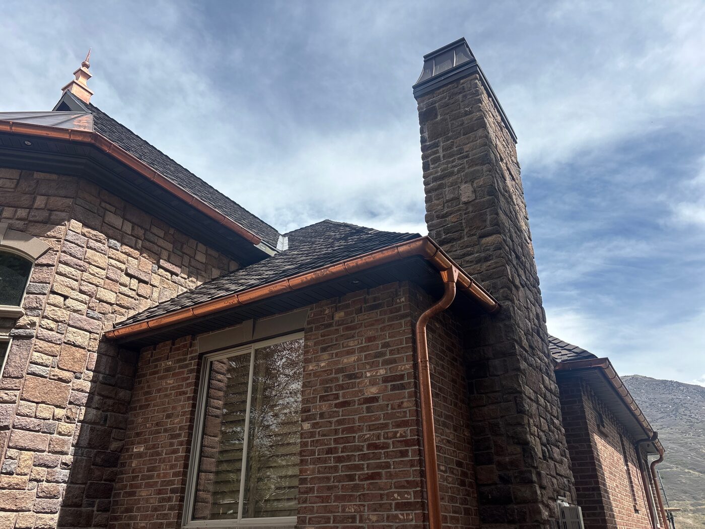 Copper gutter installation on brick luxury home — KCR Construction, Utah County